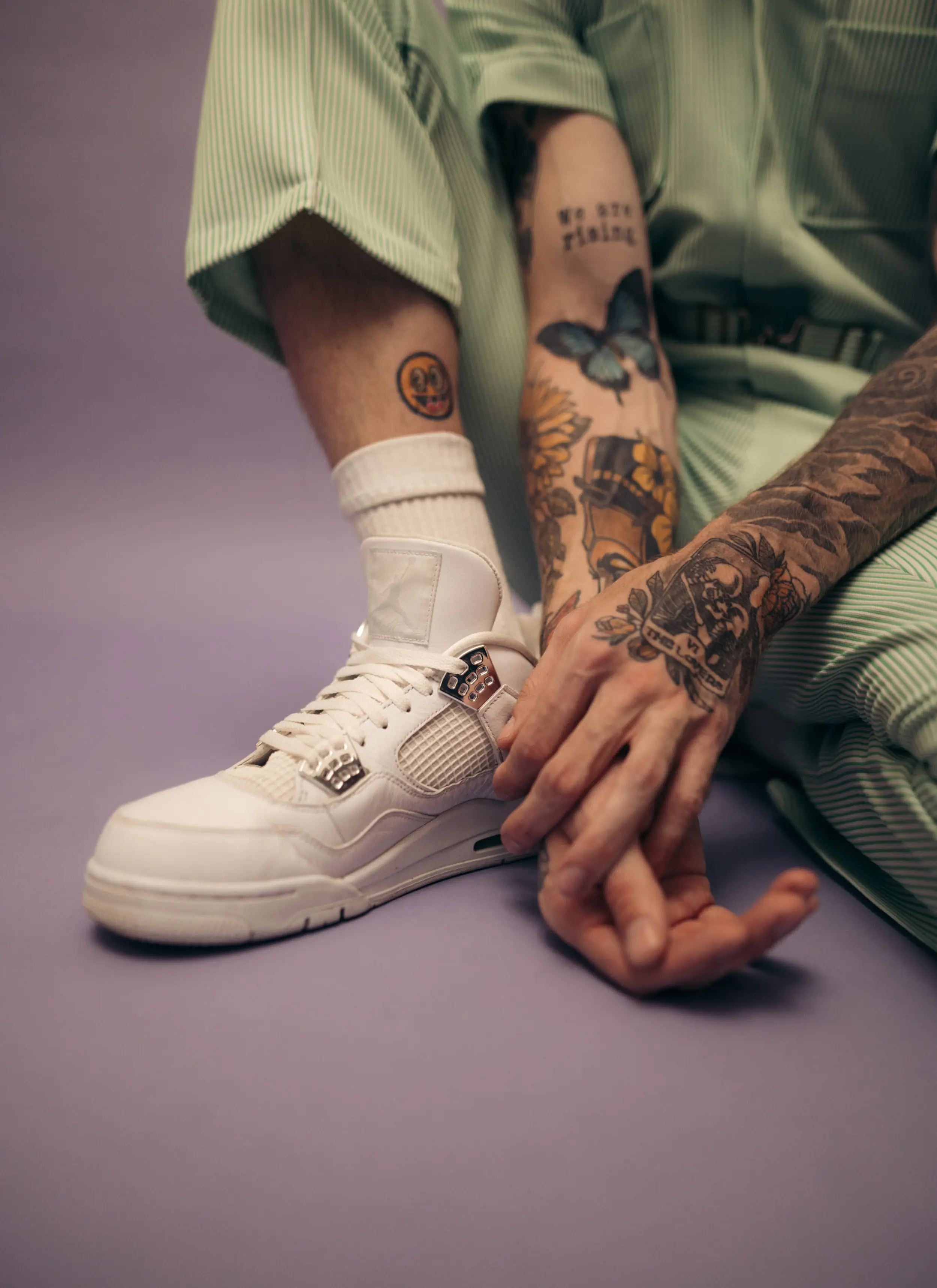 Close up of a person with sport clothes and tattoos on a purple background